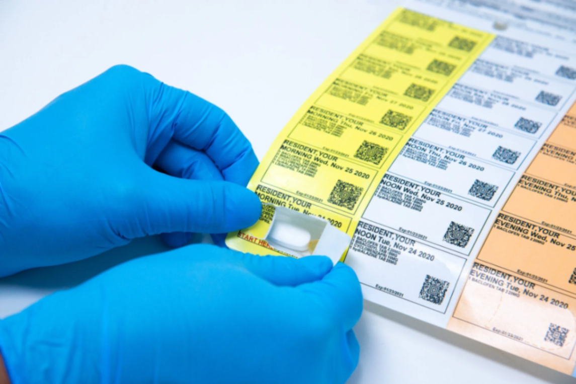Pharmacist dispensing medication from a sealed pouch